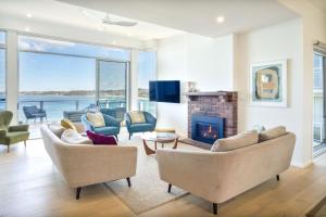 a living room with couches and a fireplace at The Sands Mollymook Luxury Beach House in Mollymook