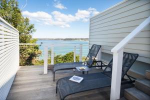 a deck with chairs and a view of the water at The Sands Mollymook Luxury Beach House in Mollymook