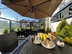 a table with breakfast foods and drinks on a balcony at Hotel Seny in Ambato