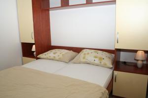 プリモシュテンにあるApartments by the sea Bilo, Primosten - 3090の枕が2つ置かれたベッドのある寝室