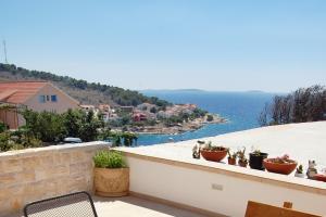 プリモシュテンにあるApartments by the sea Bilo, Primosten - 3090の鉢植えの植物が立ち並ぶバルコニー