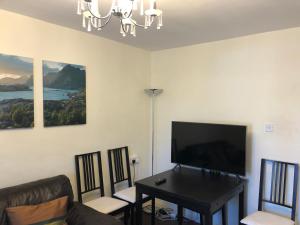 a living room with a couch and a table with a television at Lovely one bed apartment to rent in London