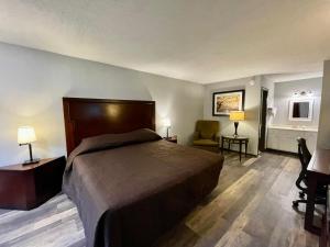 a hotel room with a bed and a chair at Alpine Village Inn in Helen