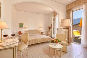 une chambre d'hôtel avec un lit, une table et des chaises dans l'établissement Hotel Tamaro, à Ascona