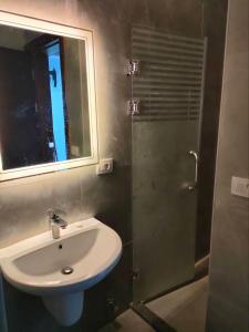 a bathroom with a sink and a shower with a mirror at Porto Said apartment in Port Said