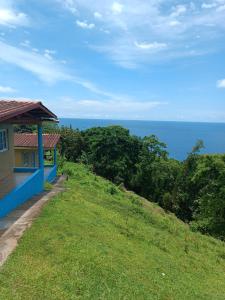 ein Haus auf einem Hügel mit dem Ozean im Hintergrund in der Unterkunft Rancho Juancho in Portobelo