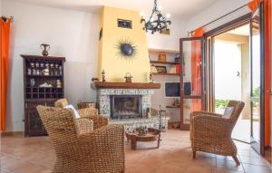 a living room with a fireplace and chairs at Stunning Home In Trabia With 3 Bedrooms, Wifi And Outdoor Swimming Pool in Trabia