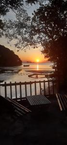 メーウ島にあるPousada Cantuáの水辺のベンチ付きのビーチでの夕日