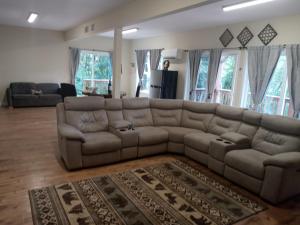 a living room with a large brown leather couch at Tranquil Creekside Mountain View Getaway in Clyde