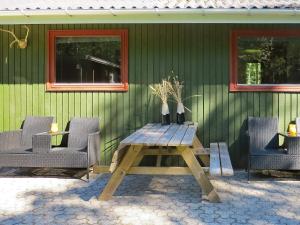 una mesa de madera con 2 sillas y 2 jarrones en 4 person holiday home in Hals, en Hals
