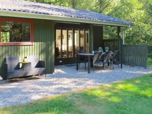 a patio with a table and chairs in front of a house at 4 person holiday home in Hals in Hals