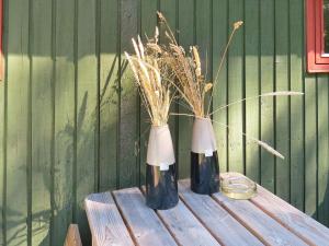 dos jarrones sentados en una mesa de madera con un poco de hierba en 4 person holiday home in Hals, en Hals