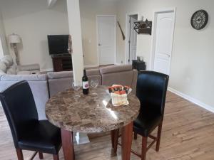 a table with a bottle of wine and two chairs at Tranquil Creekside Mountain View Getaway in Clyde