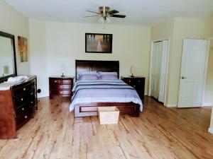 een slaapkamer met een bed, 2 dressoires en een ventilator bij Tranquil Creekside Mountain View Getaway in Clyde