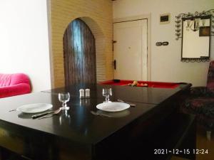 uma sala de jantar com uma mesa com dois pratos em Nice house em Alexandria