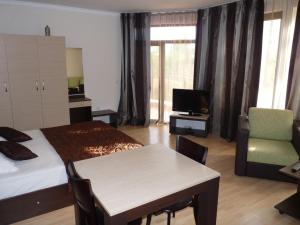 a hotel room with a bed and a table and a tv at Cosy Studio 9 in Saints Constantine and Helena
