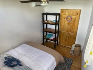 1 dormitorio con 1 cama y puerta de madera en Barcaza de 2 habitaciones a 2 km de Playa Potrero, en Potrero