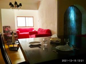 Nice house في الإسكندرية: غرفة معيشة مع طاولة وأريكة حمراء