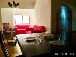 a living room with a table and a red couch at Nice house in Alexandria