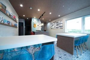 小樽的住宿－The BEEHIVE OTARU，厨房配有白色的柜台和蓝色的椅子