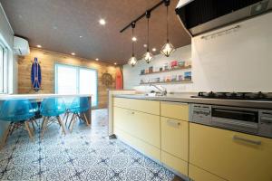 小樽的住宿－The BEEHIVE OTARU，厨房配有水槽和带蓝色椅子的台面