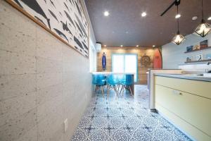 a kitchen with a counter and blue stools at The BEEHIVE OTARU in Otaru