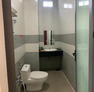 a bathroom with a toilet and a sink at Khách Sạn HOÀNG KIM in Bạc Liêu