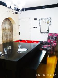 a dining room with a black table and a chair at Nice house in Alexandria