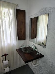 a bathroom with a bowl sink and a mirror at Buddha Suítes in Pipa
