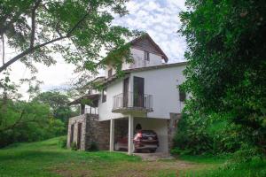 ein Haus mit einem davor geparkt in der Unterkunft Casa Camino a las Pozas in Xilitla