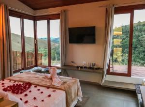 a bedroom with a bed and a large window at Cabana Sol - Estalagem Meraki, Cunha SP in Cunha +49 photos