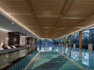 a swimming pool in a building with glass windows at InterContinental Hangzhou Liangzhu, an IHG Hotel in Hangzhou