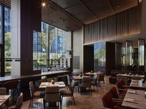 - un restaurant avec des tables, des chaises et de grandes fenêtres dans l'établissement InterContinental Hangzhou Liangzhu, an IHG Hotel, à Hangzhou