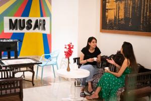 twee vrouwen op een bank in een kamer bij Citylights By MUSAFIR in Udaipur