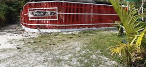 ein roter Zaun auf der Seite eines Strandes in der Unterkunft Pousada Cantuá in Ilha do Mel