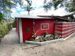a red house with plants in front of it at Pousada Cantuá in Ilha do Mel