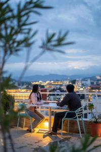 two people sitting at a table on a balcony at Citylights By MUSAFIR in Udaipur