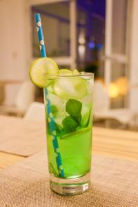 a green drink with a lime and blue straw at Hotel Gran Palma Piura in Piura