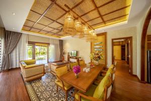 a living room with a wooden table and yellow chairs at Sao Mai Beach Resort in Tuy Hoa