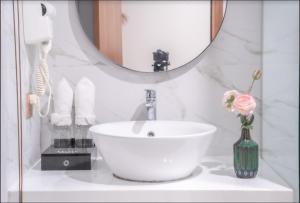 a bathroom with a white sink and a mirror at Maple Suite Hotel & Apartment in Danang