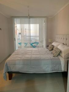 a bedroom with a large bed with a large window at Departamento frente al mar en Arica in Arica