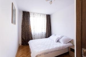 a bedroom with a white bed and a window at Central Apartment Targu Mures in Târgu-Mureş