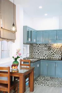 a kitchen with blue cabinets and a table with fruit on it at Sunny House in Da Nang