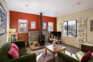 a living room with couches and a fireplace at Criffel Peak View Bed and Breakfast in Wanaka