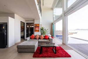 a living room with a couch and a red rug at Raya Beachloft in Rawai Beach