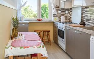 een keuken met een tafel en stoelen en een fornuis bij Stunning Apartment In Gdansk With Kitchen in Gdańsk