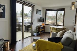 a living room with a couch and a table at MenardsNZ Ecosanctuary Accommodation in Twizel