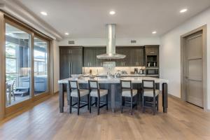 a kitchen with a large island with bar stools at Premium Three Bedroom in Park City +6 photos