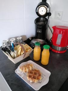 uma bancada com alimentos para pequeno-almoço e um liquidificador em Le Garni Vendémiaire em Vesoul