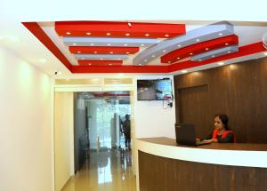 a woman sitting at a counter with a laptop at PEROOR INN in Trivandrum